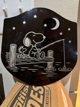 Angled view of the finished engraved Snoopy and Woodstock fishing plaque