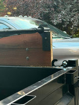 J Fab tarp bracket mounted on a wooden dump trailer sideboard supporting the tarp bar