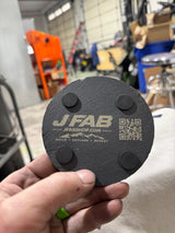 Back of J Fab slate coaster showing branding, QR code and four protective pads