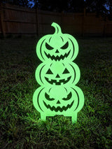 Stacked pumpkin metal yard stake shown glowing in darkness