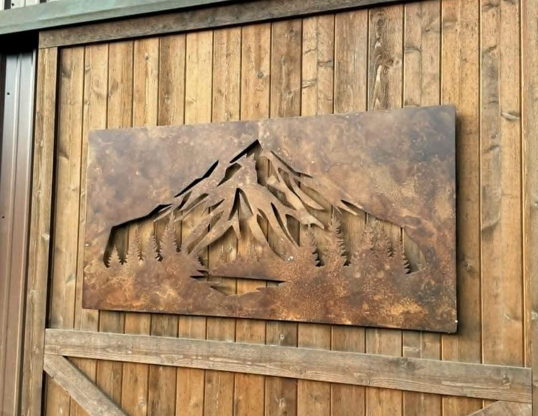 Mountain and forest cutouts in one rectangular metal wall-art panel